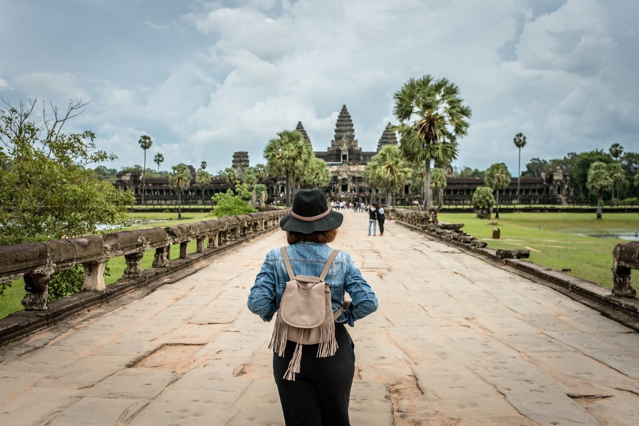 Women tourists wear jacket jeans walking into Angkor Wat landmark in Siem Reap, Cambodia. Angkor Wat inscribed on the UNESCO World Heritage List in 1992